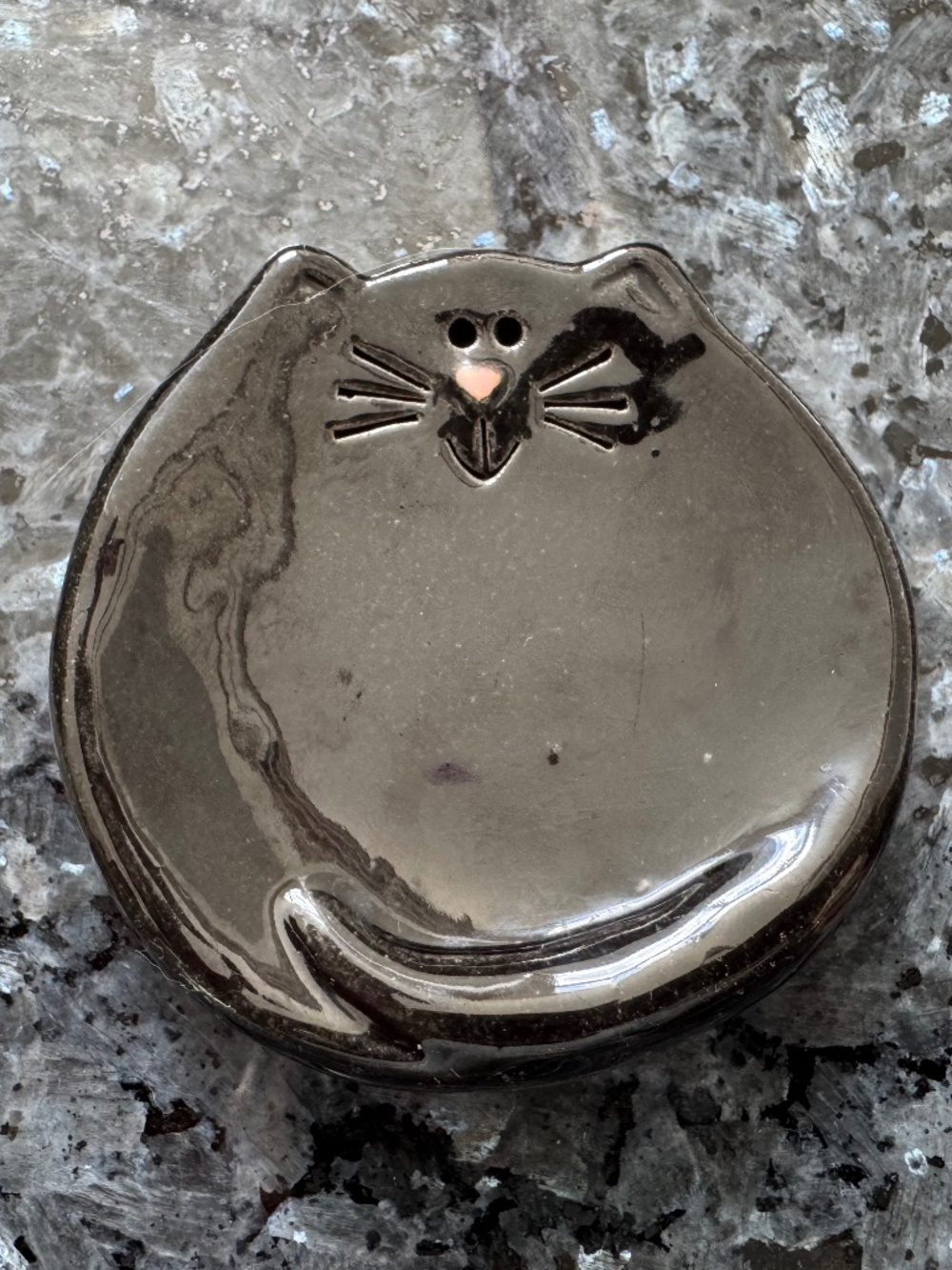 This adorable ceramic trinket dish in the shape of a cat face is a charming addi